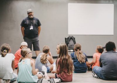Students gathering while sitting on the floor.