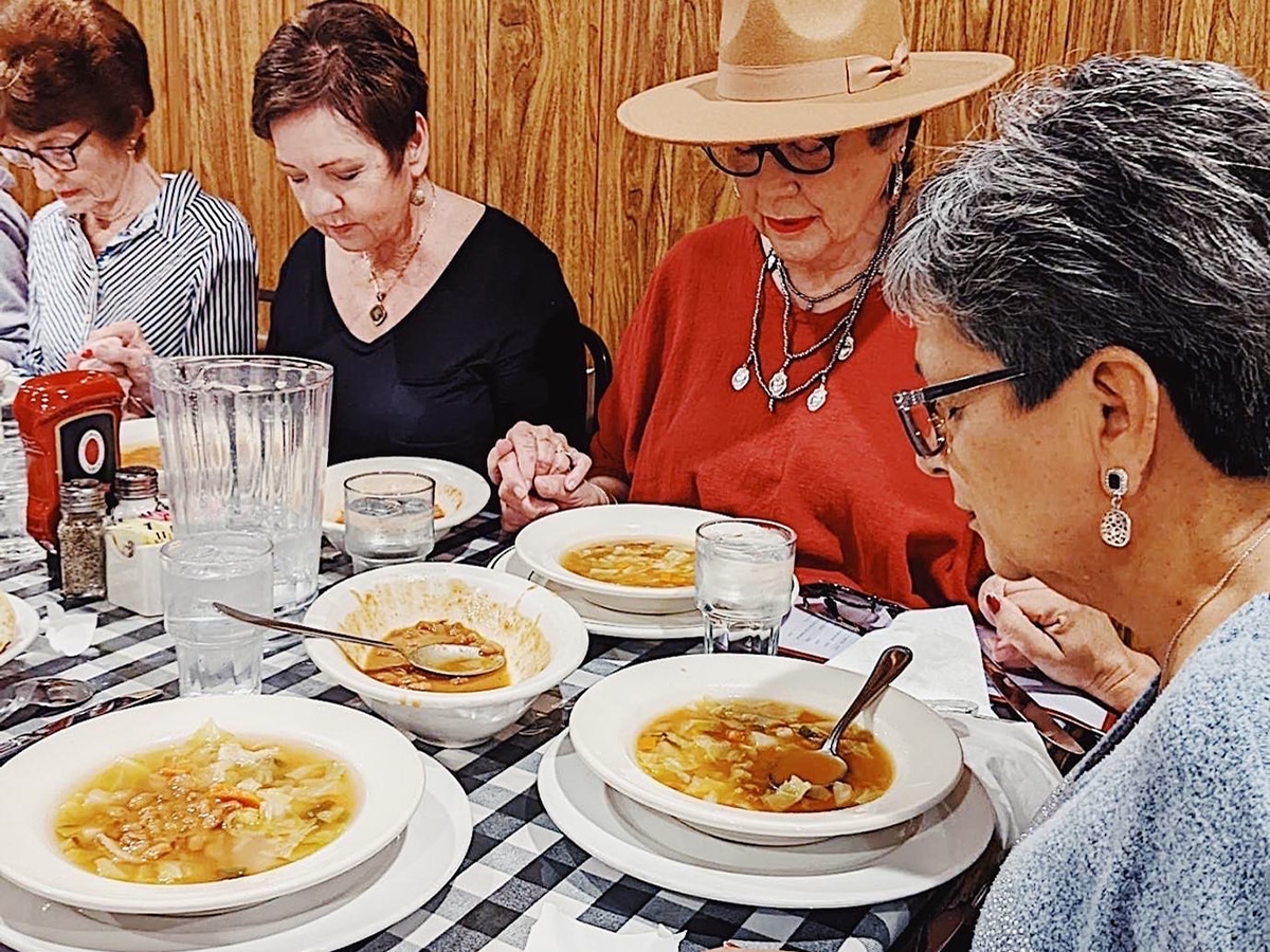 Women Praying A group of widowed women praying for their food.