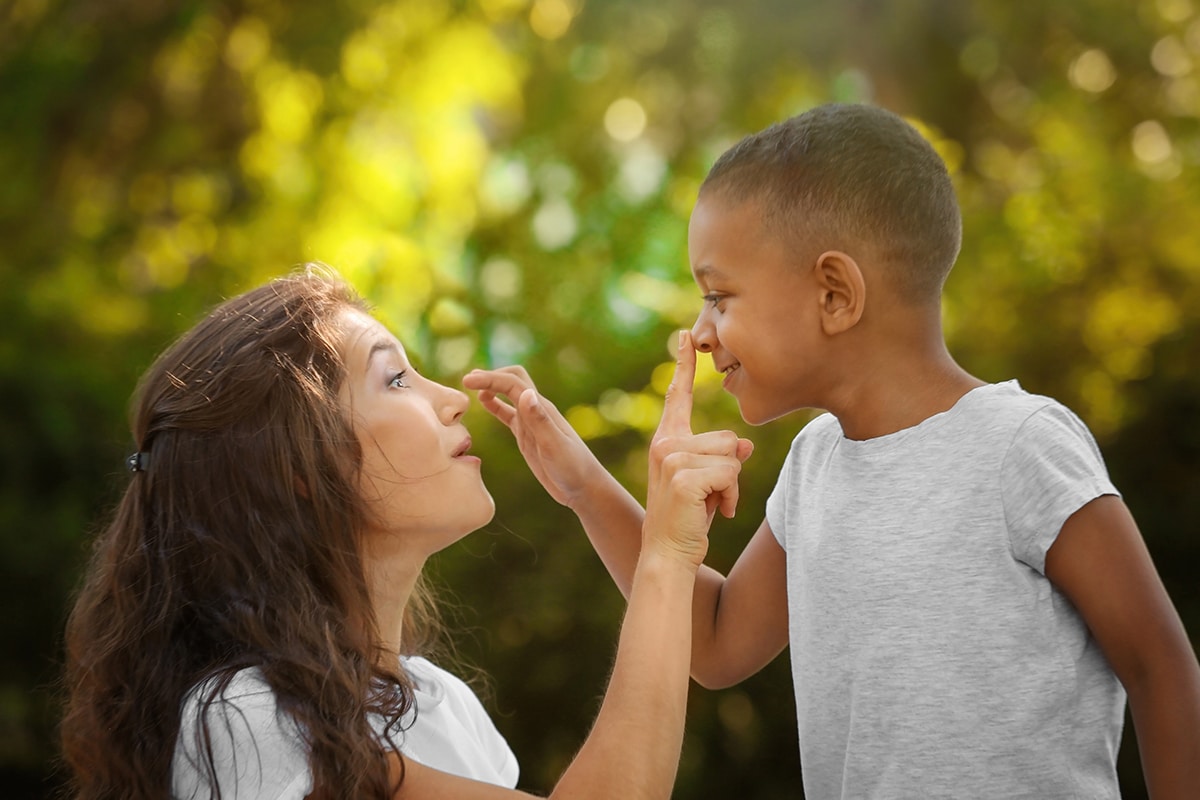 Mom and adopted son touching their noses.