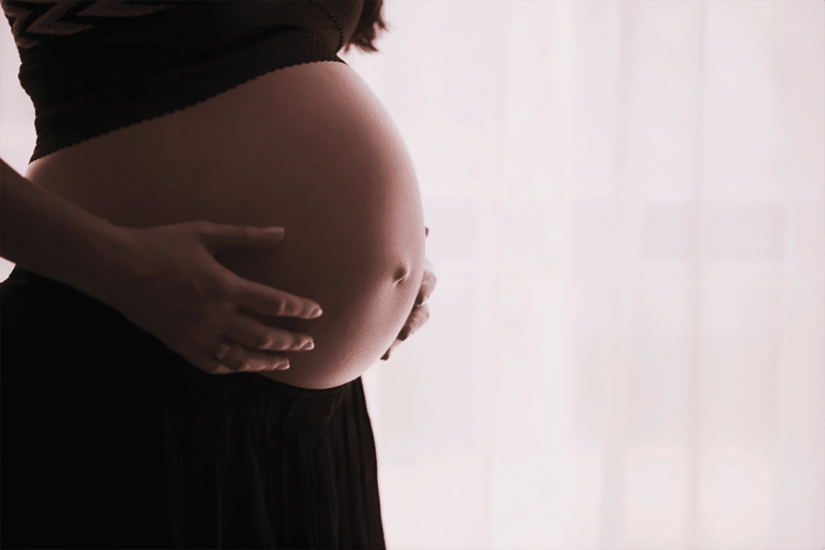 Pregnant woman holding her tummy.