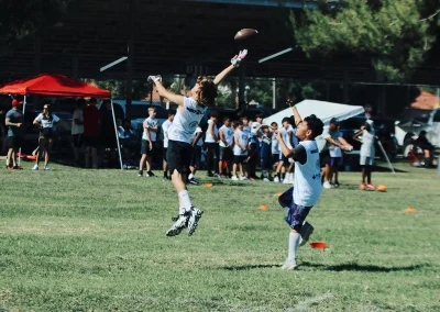 Built 2 Last Sports: Football player catching the football mid air.
