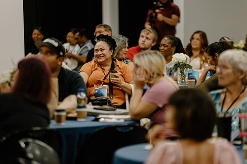 Group of diverse church and community leaders seated at round tables during a CityServe training event, representing the power of collaboration and unity in Christ.