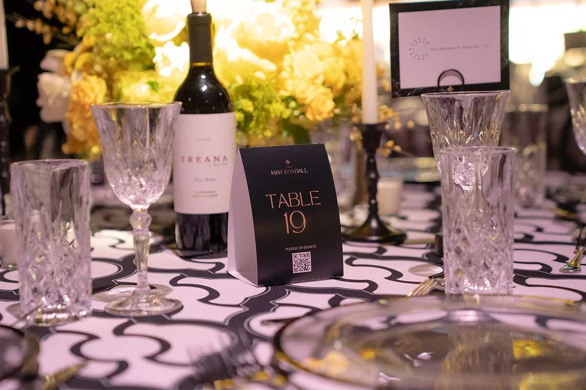 Close-up of elegant table detail with wine, crystal glasses, and Table 19 sign at the Bakersfield Mayor’s Ball.