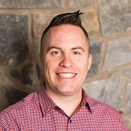 Nick Blevins smiling in front of a stone wall, church leadership strategist and ministry training speaker.